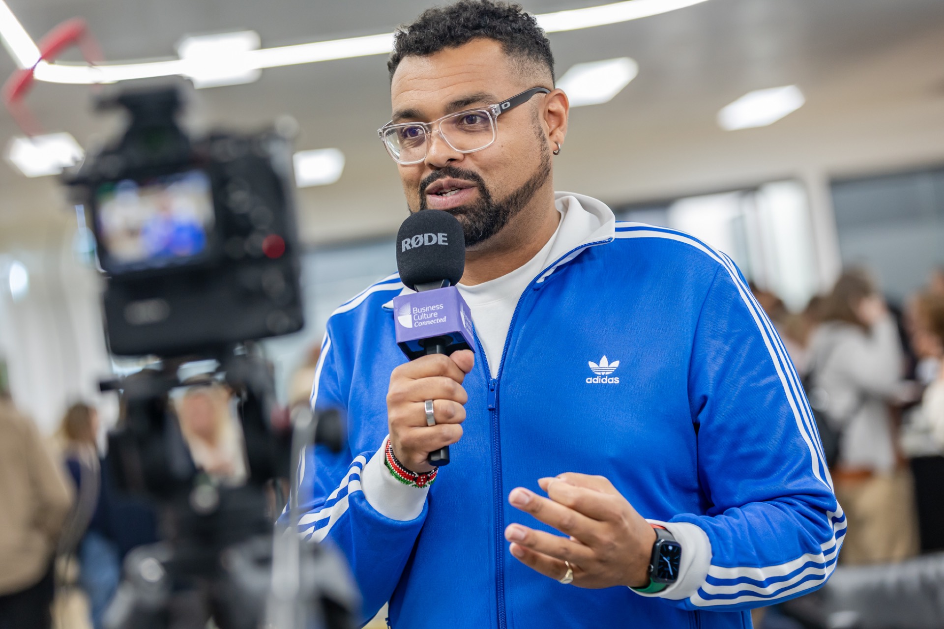 Tom on camera with a microphone, in conversation